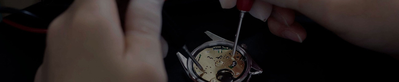 Horlogereparatie met handen en gereedschap, close-up van het horlogemechanisme.