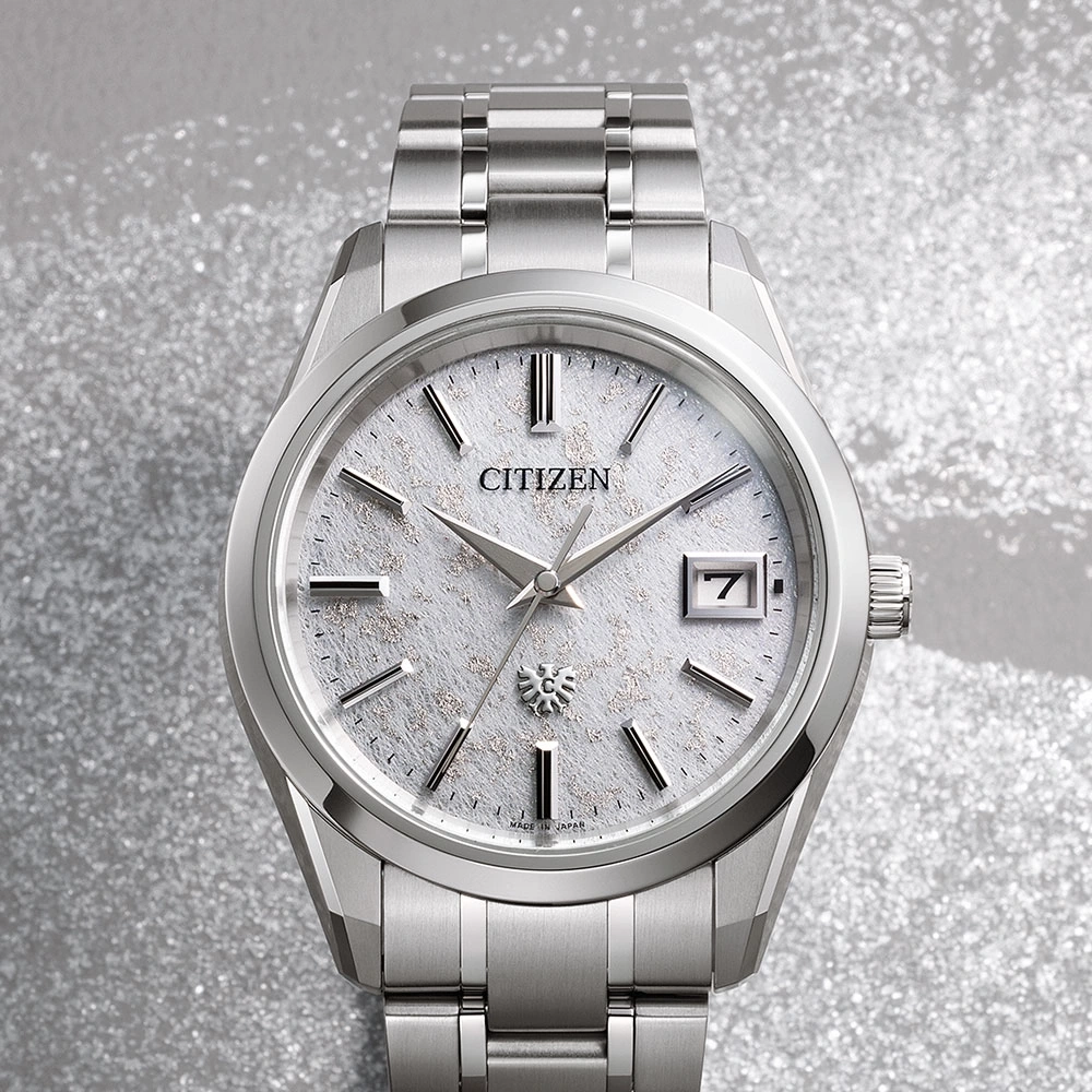 Citizen horloge met zilveren band en een witte textuur wijzerplaat, datumweergave.