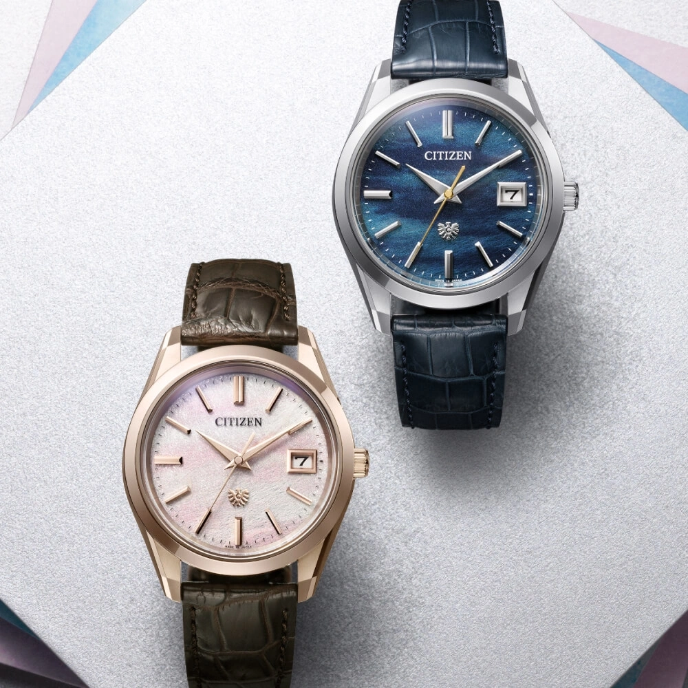 Twee Citizen horloges met leren bandjes op een wit oppervlak.