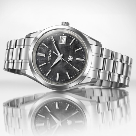 Citizen-Uhr mit dunklem Zifferblatt und silbernem Armband, elegantes Design.