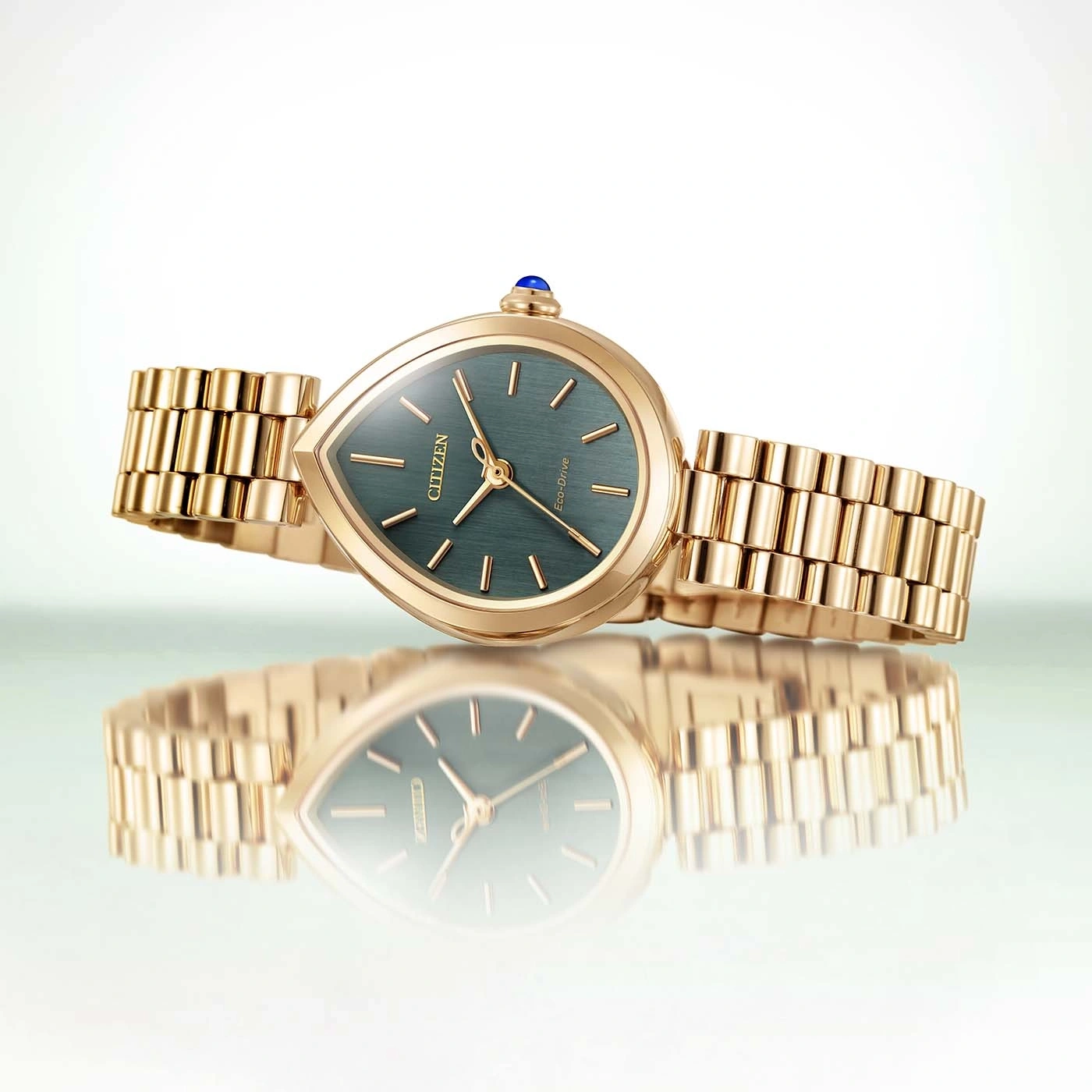 Een gouden Citizen Eco-Drive horloge met een druppelvormige wijzerplaat en groen wijzerplaat.