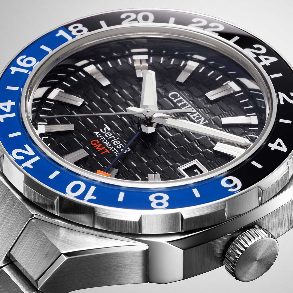 Close-up van een Citizen horloge met een zwarte en blauwe bezel en een getextureerde wijzerplaat.