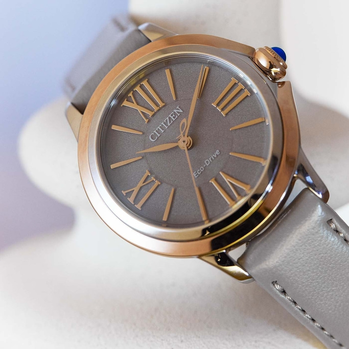 Citizen Eco-Drive horloge met grijze wijzerplaat en leren band, gouden accenten.