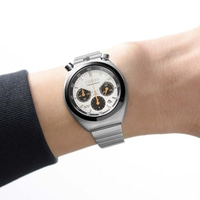 Een man draagt een zilveren Citizen chronograaf horloge om zijn pols.