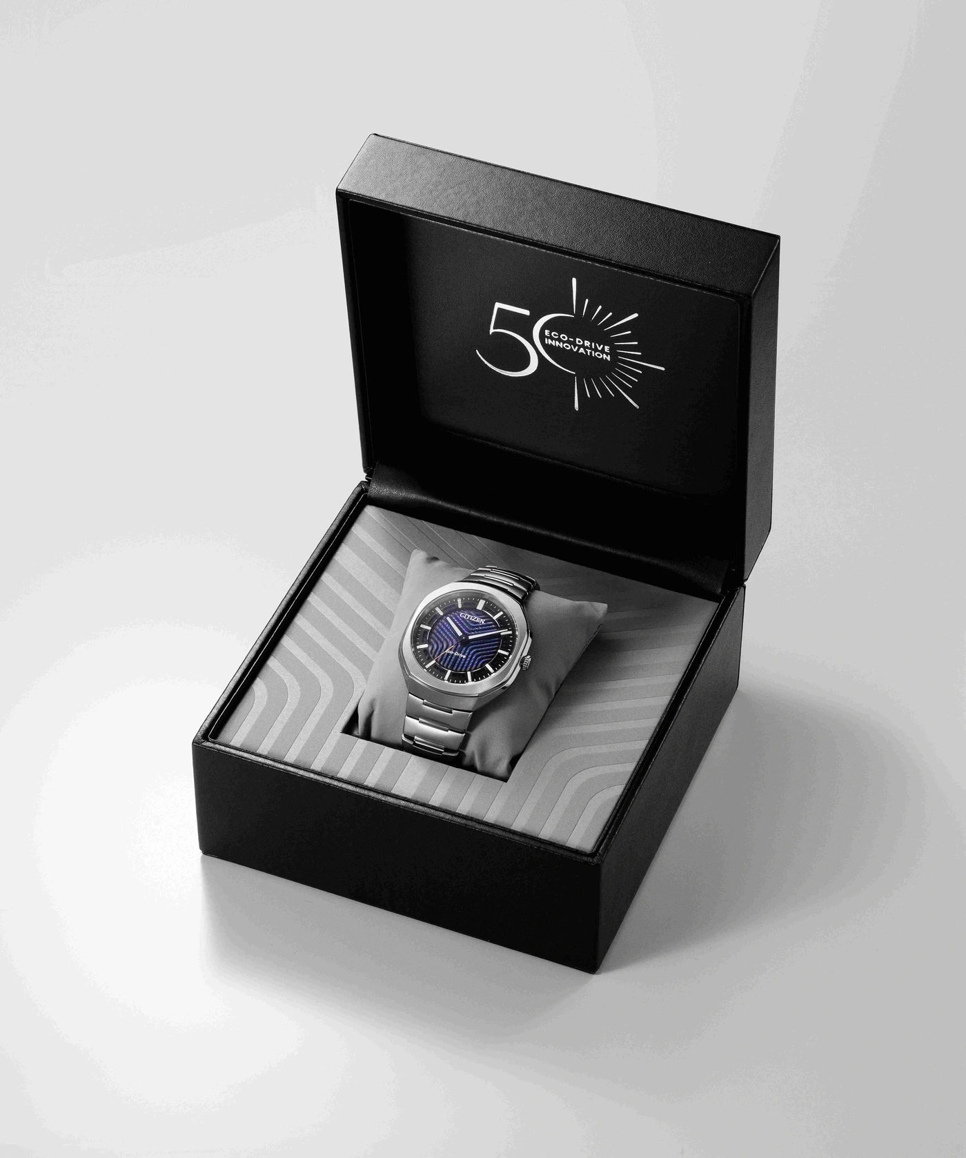 Een zilveren Citizen Eco-Drive horloge in een open zwarte doos met 50-jarig jubileumlogo.