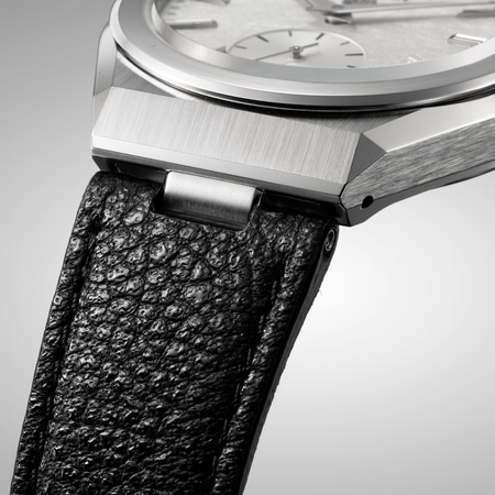 Close-up van een luxe horloge met een zwarte leren band en zilveren details.