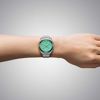 Een mannenpols met een groen Citizen chronograaf horloge.