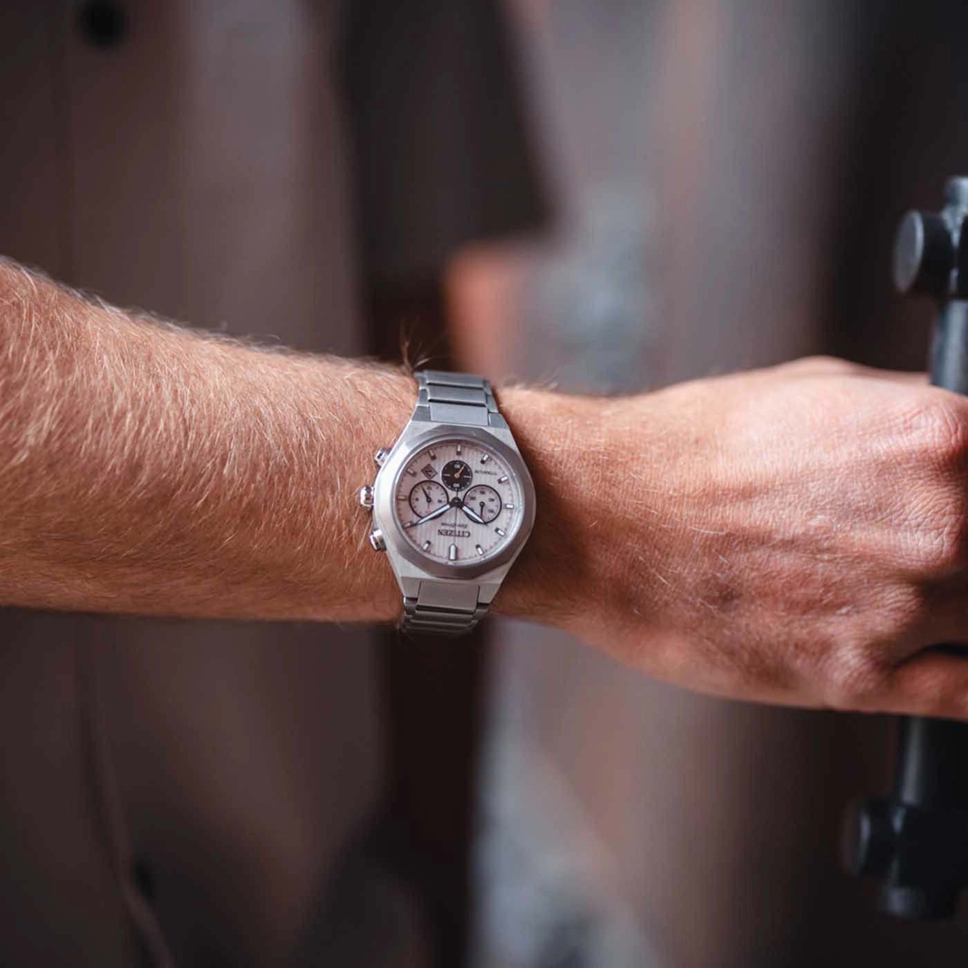Close-up van iemands pols met een zilveren Citizen horloge.