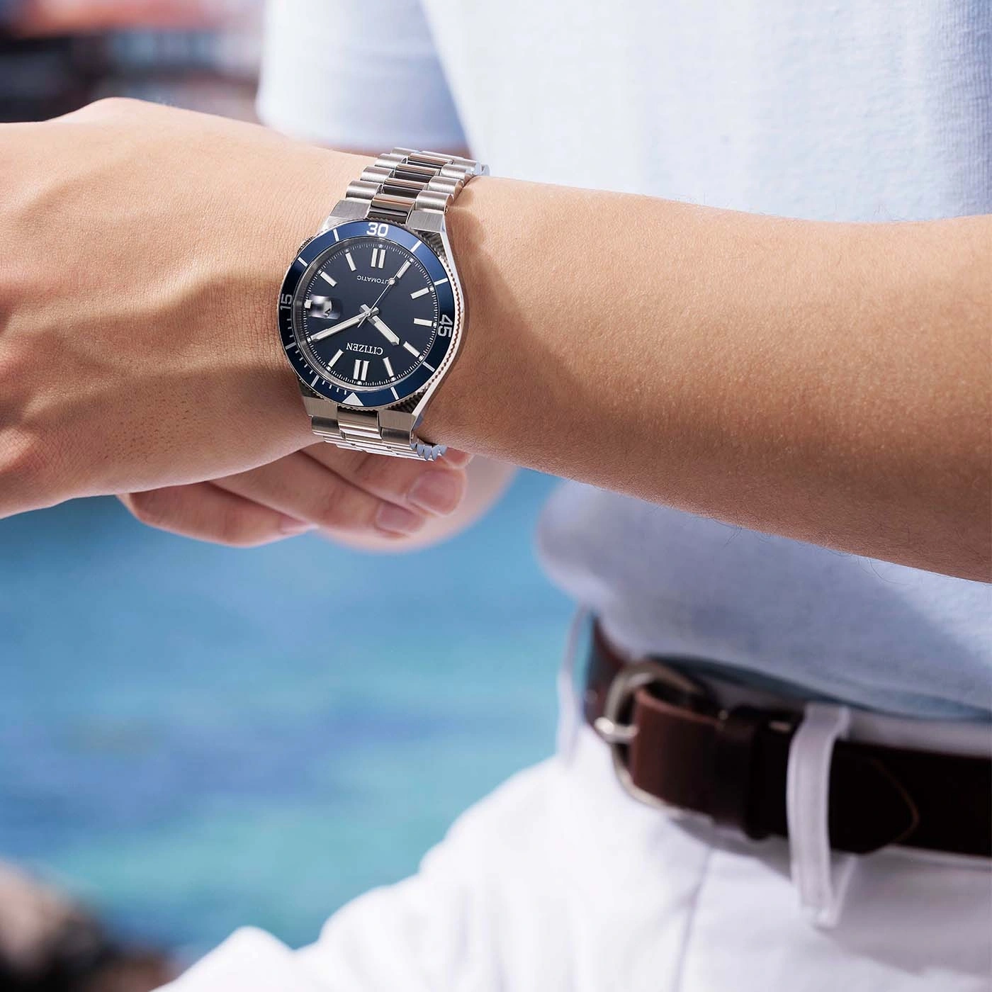 Man draagt een Citizen automatische horloge met blauwe wijzerplaat om zijn pols.
