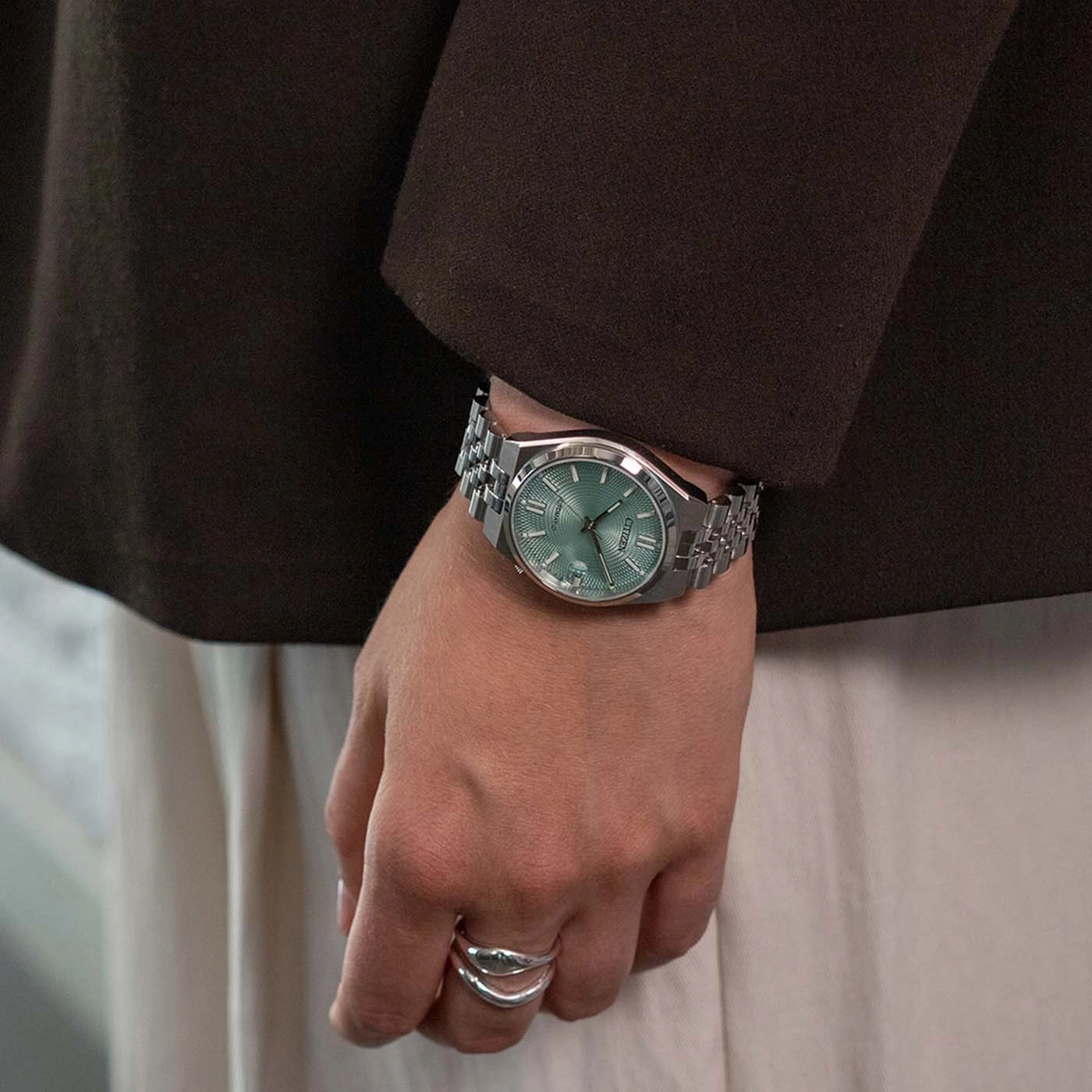 Een persoon die een horloge en ringen draagt