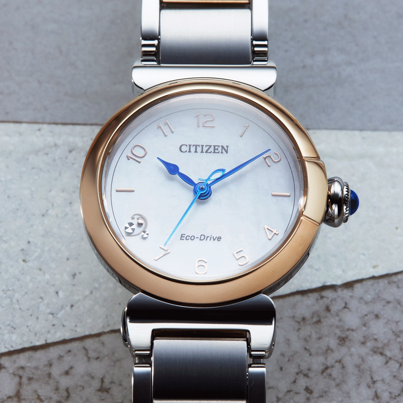 Citizen Eco-Drive horloge met een gouden en zilveren band en blauwe wijzers.