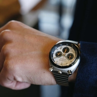 De pols van een man met een zilveren Citizen chronograaf horloge.