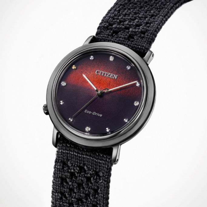 Citizen horloge met een donkere wijzerplaat en een textuur band.