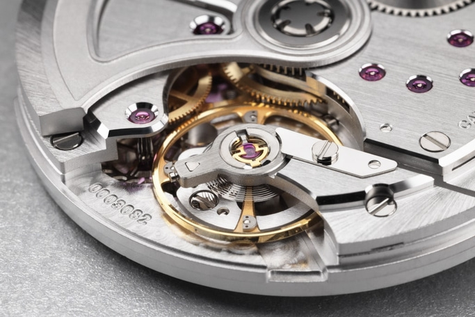 Close-up van een horlogemechanisme met tandwielen en ingewikkelde details.