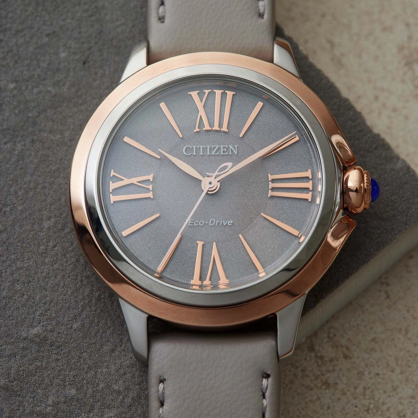 Citizen horloge met grijze wijzerplaat, roségouden accenten en grijze leren band.