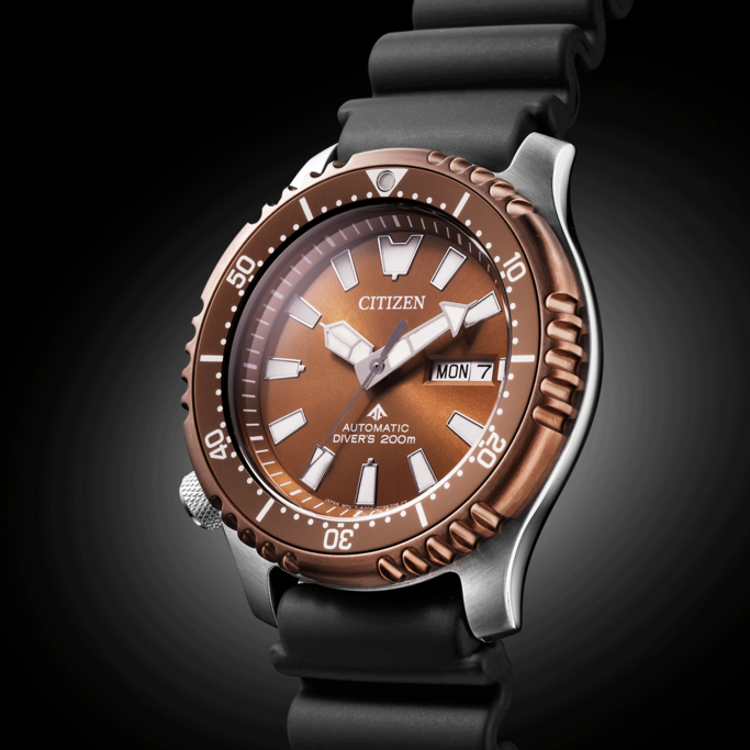 Citizen horloge met bruine wijzerplaat, zwarte band en dagweergave. Automatisch duikhorloge.