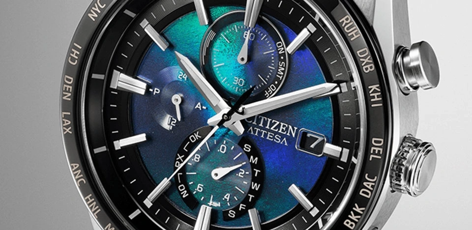 Citizen Attesa horloge met blauw en groene wijzerplaat, tijd- en datumweergave.