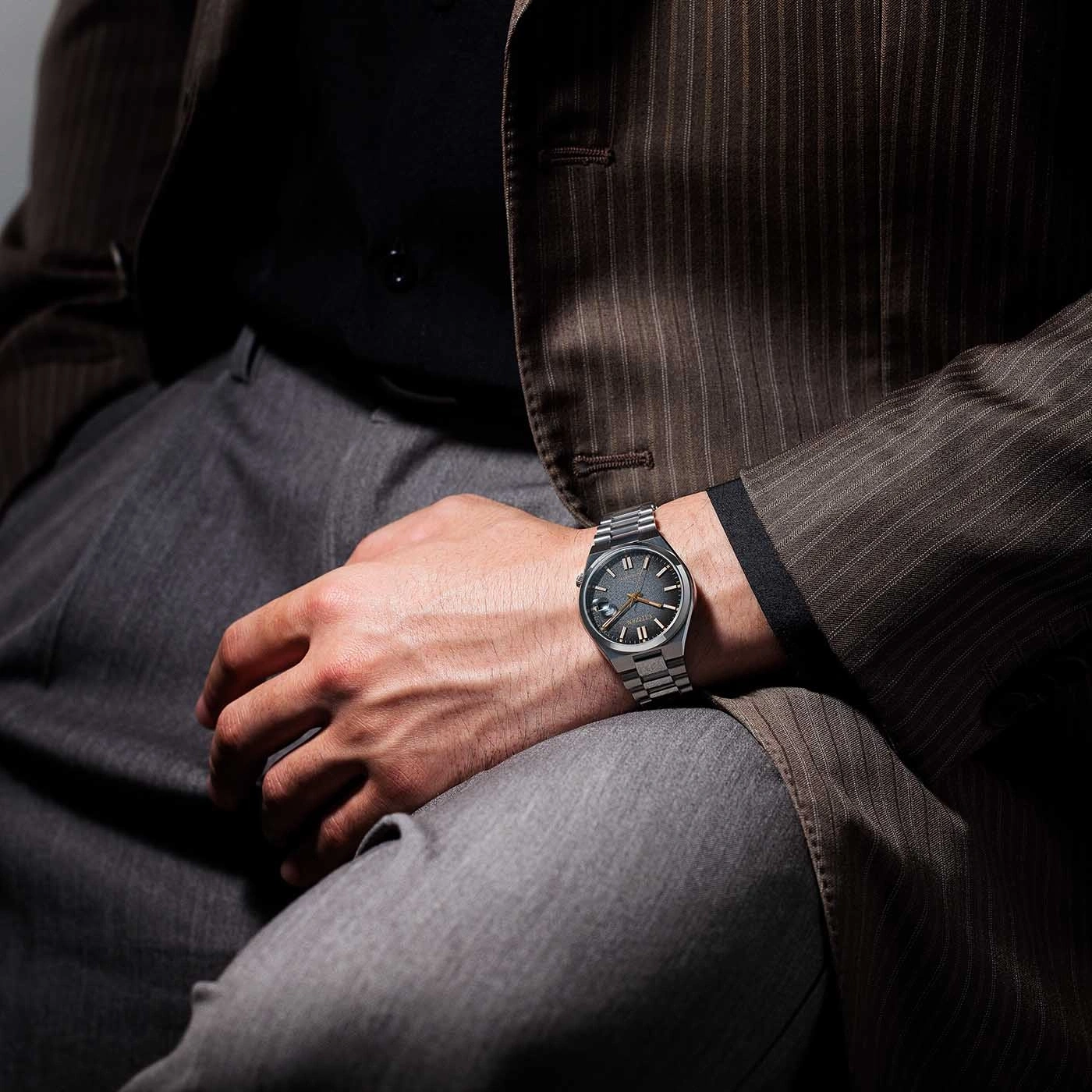 Man met horloge, pak en broek. Polshorloge om de pols, elegant gekleed.