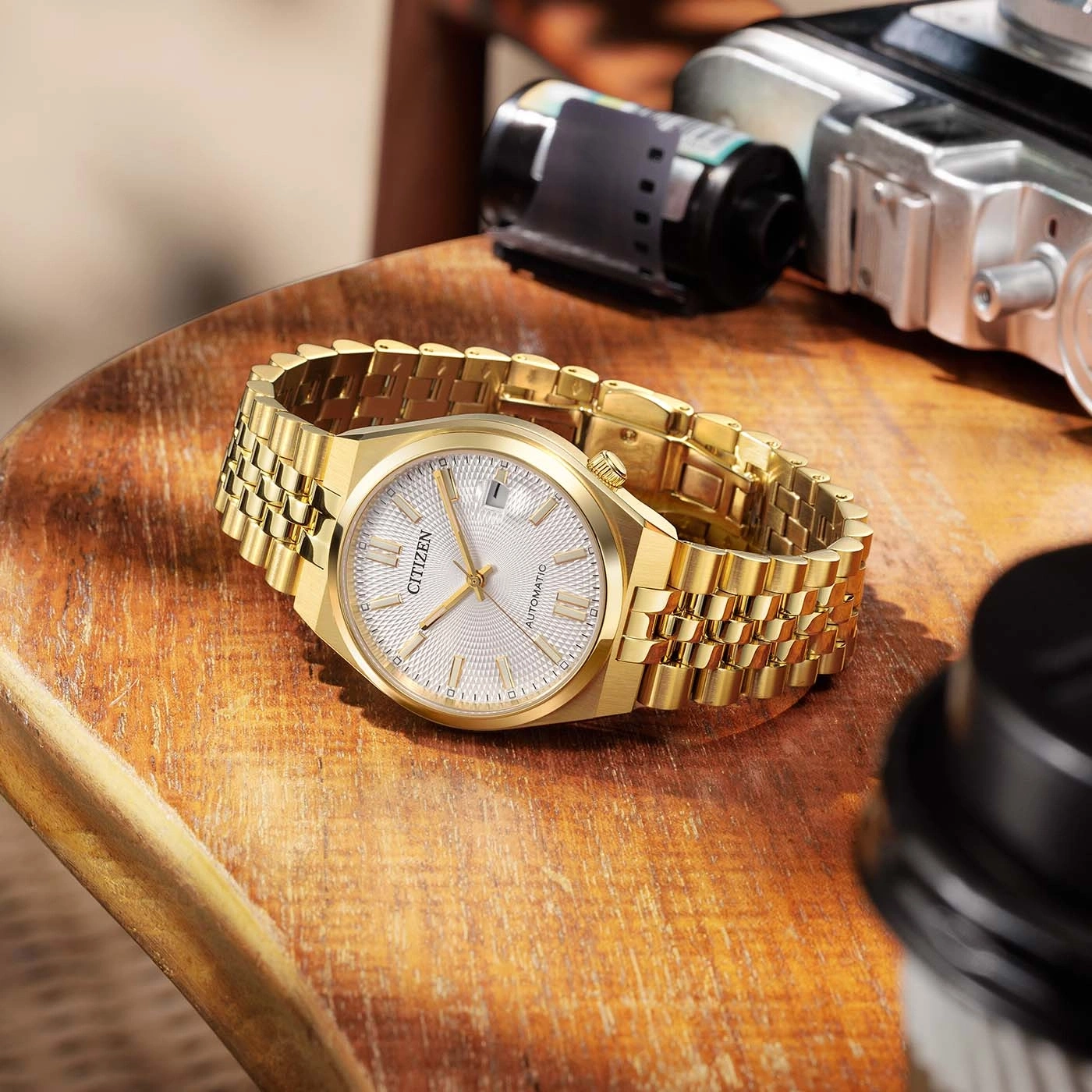 Gouden Citizen horloge met automatische beweging op houten ondergrond.