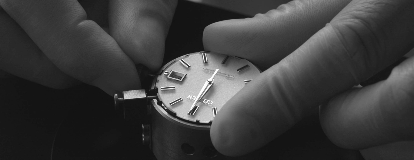 Handen die een horloge vasthouden. Horlogereparatie. Close-up van de wijzerplaat.