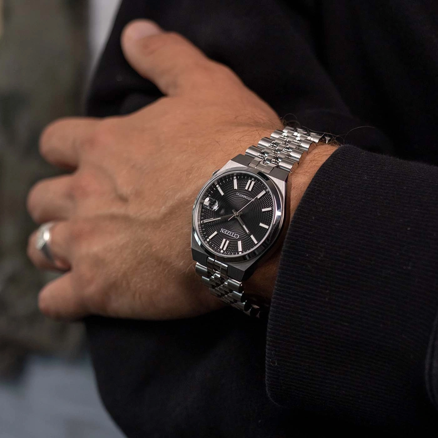 Een man draagt een Citizen automatisch horloge om zijn linkerpols.
