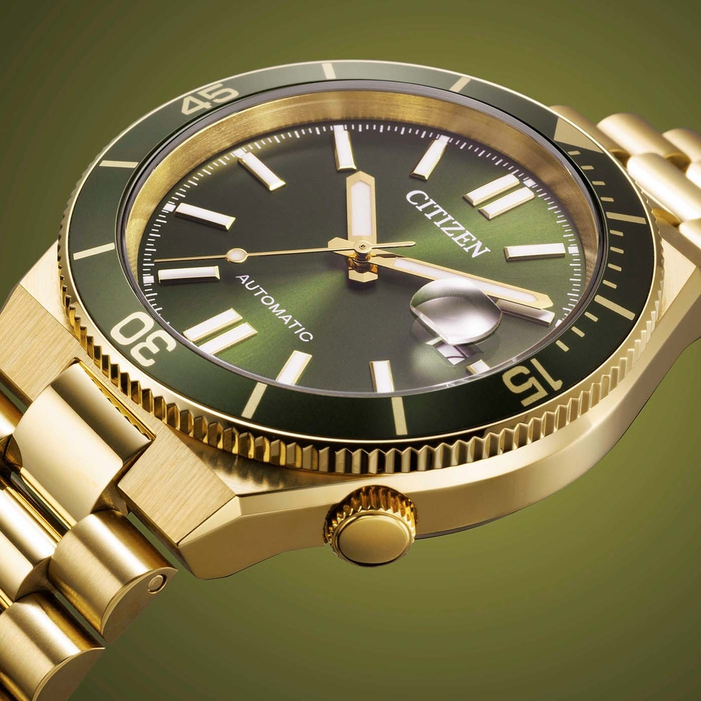 Close-up van een gouden Citizen automatische horloge met groene wijzerplaat en lunette.