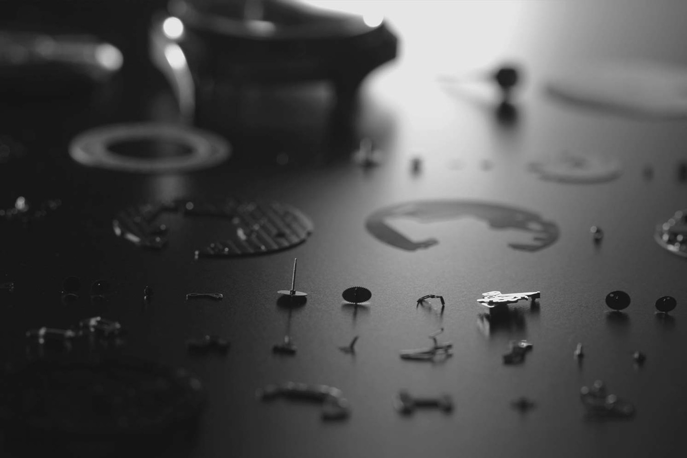 Horloge onderdelen verspreid op een donker oppervlak, gedemonteerd voor reparatie.