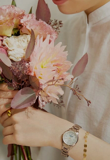 Vrouw met bloemen, draagt horloge en armband, close-up