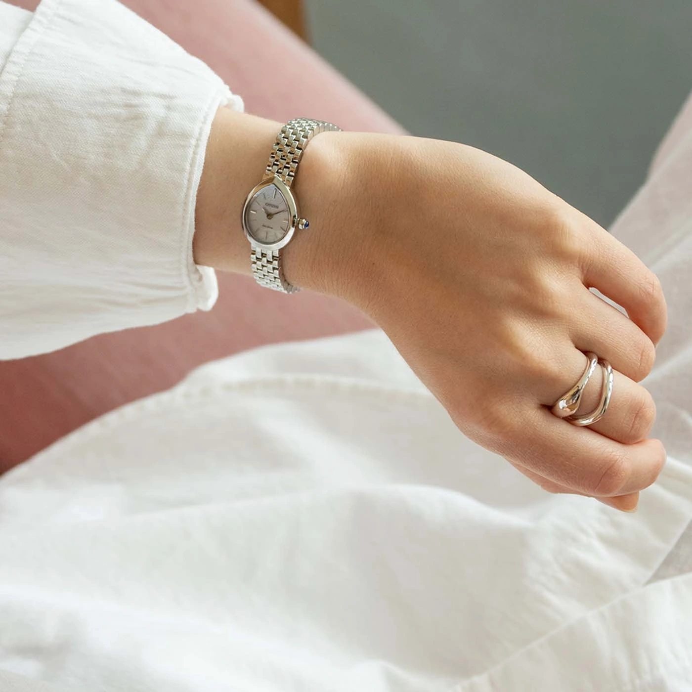 Een vrouwenhand met een zilveren horloge en ringen.