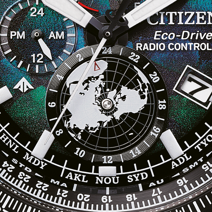 Close-up van een Citizen horlogekast met meerdere wijzerplaten en wereldkaart.