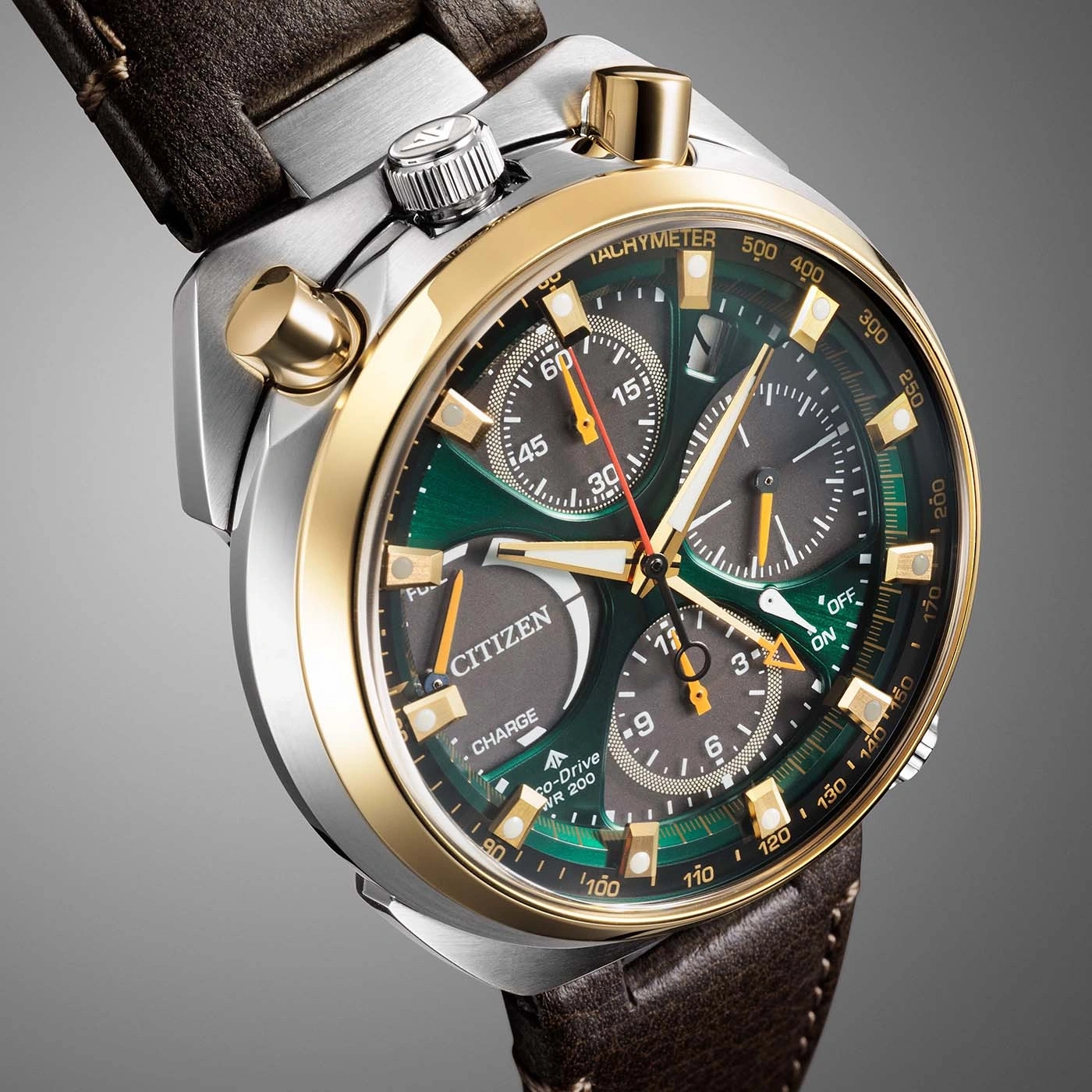 Een close-up van een groen en gouden Citizen Eco-Drive chronograaf horloge met een bruine leren band.