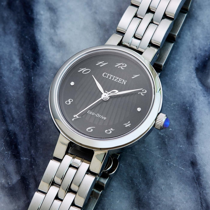 Citizen horloge met donkere wijzerplaat en zilveren band op marmeren oppervlak.