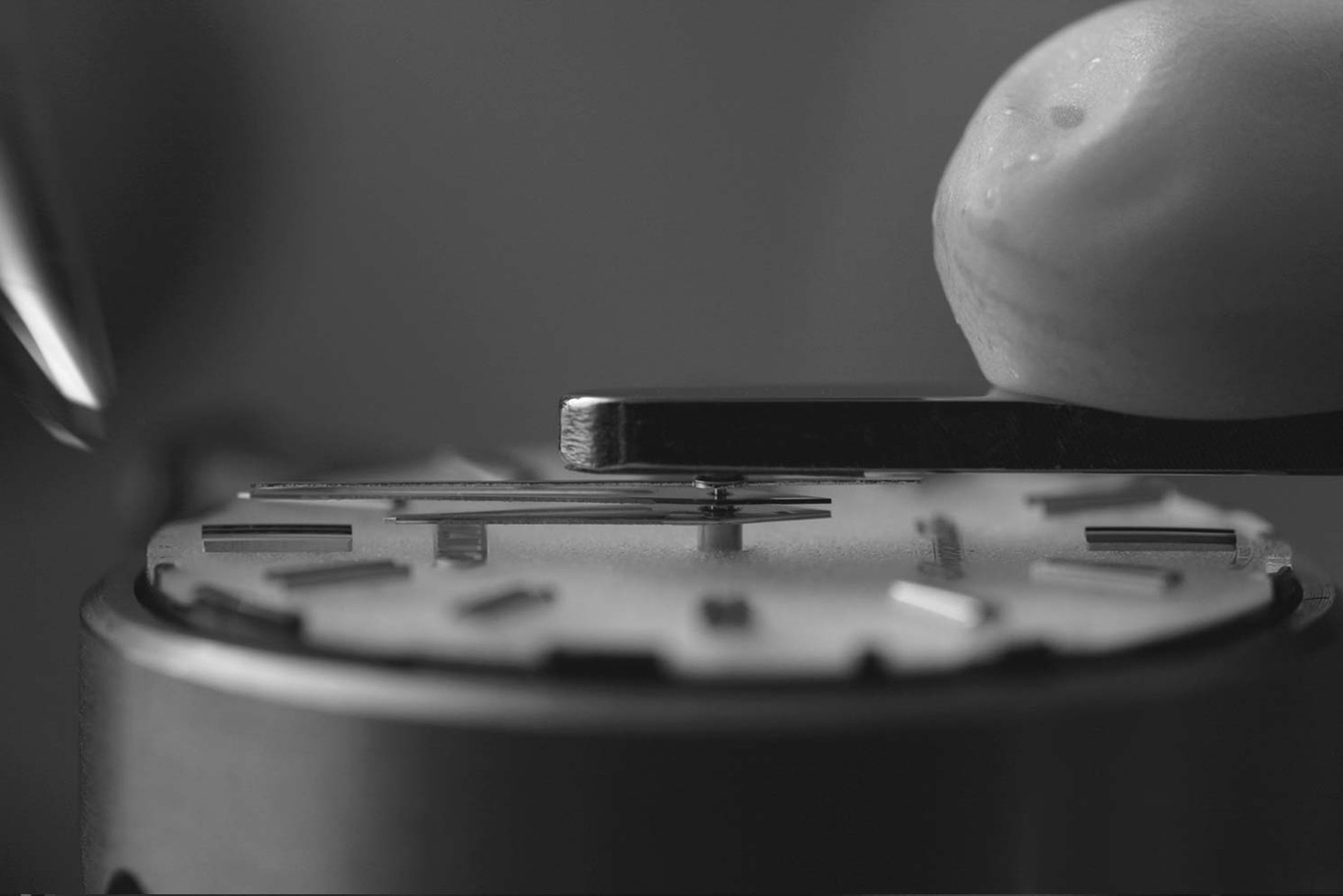 Close-up van horlogemechanisme dat met precisie en gereedschap wordt geassembleerd.