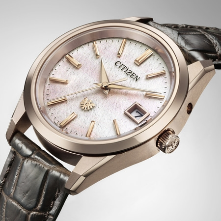Citizen horloge met witte wijzerplaat, gouden wijzers en leren band. Elegant design.