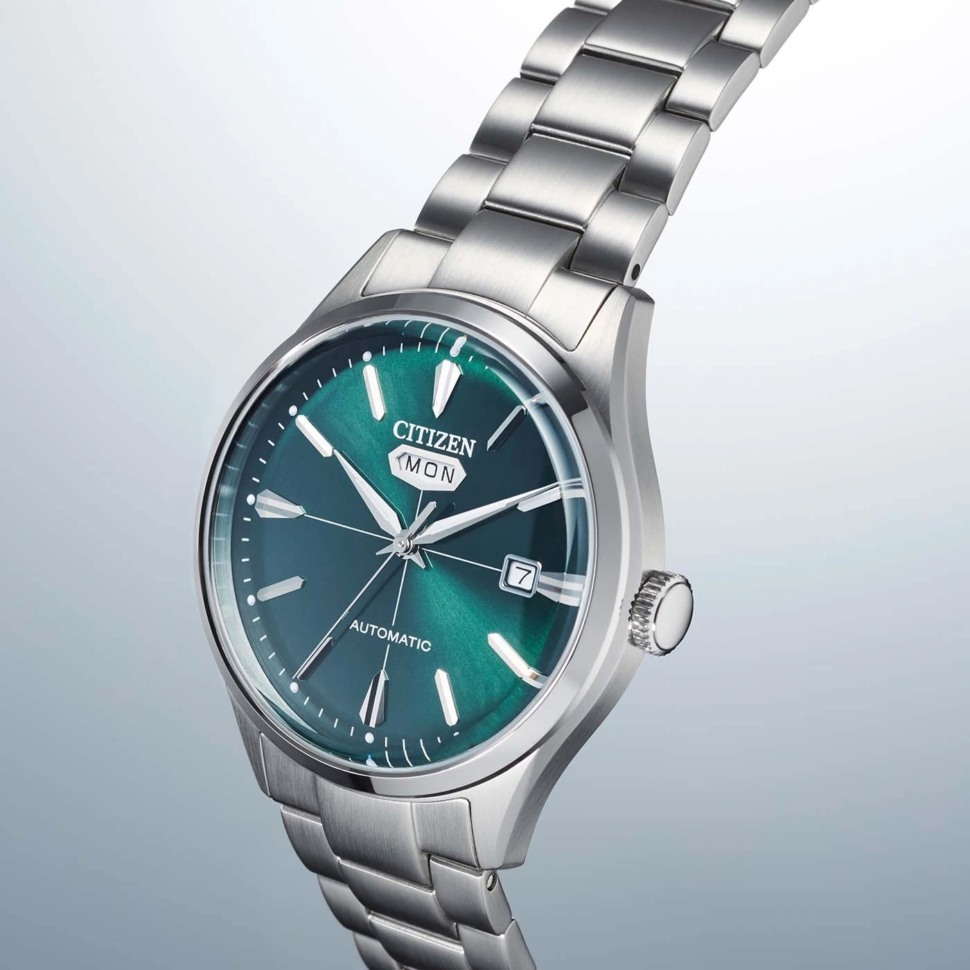 Close-up van een Citizen automatisch horloge met groene wijzerplaat en zilveren band.