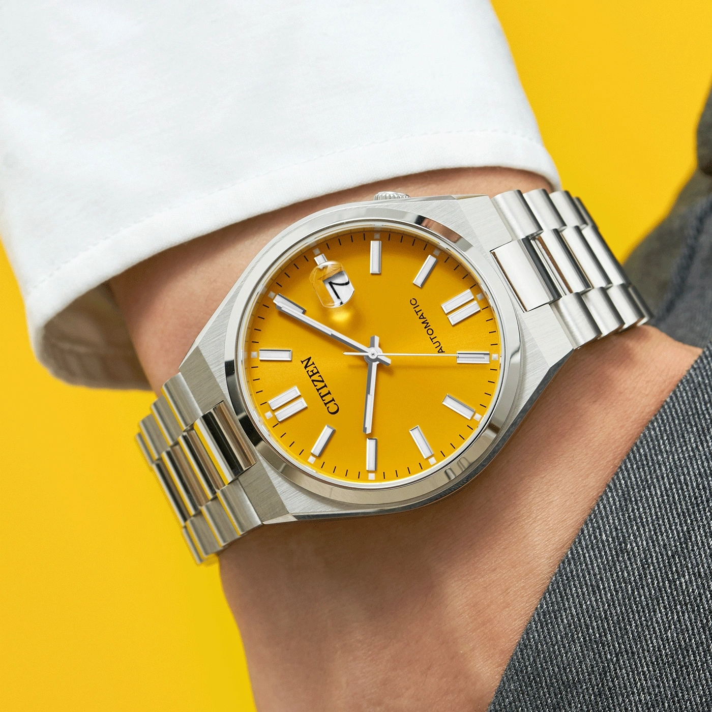 Citizen horloge met gele wijzerplaat en zilveren band om de pols