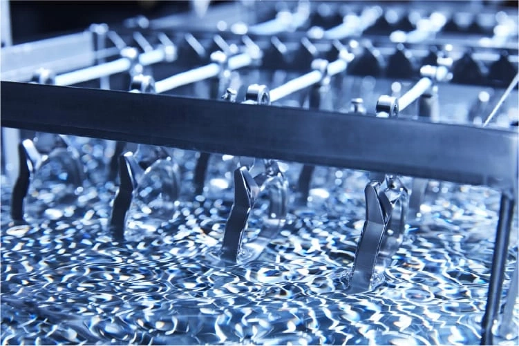 Metalen onderdelen die in een vloeistof worden gedompeld, industrieel proces, close-up.