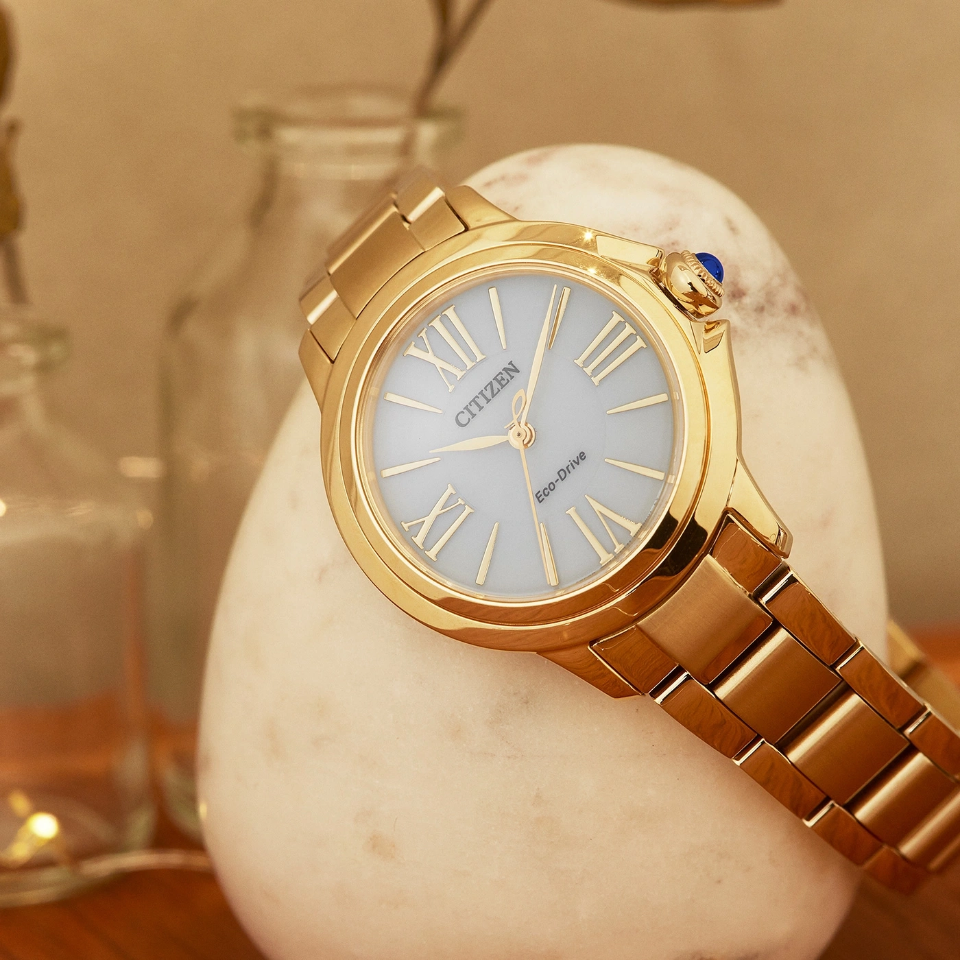 Gouden Citizen horloge met lichtblauwe wijzerplaat op een witte steen
