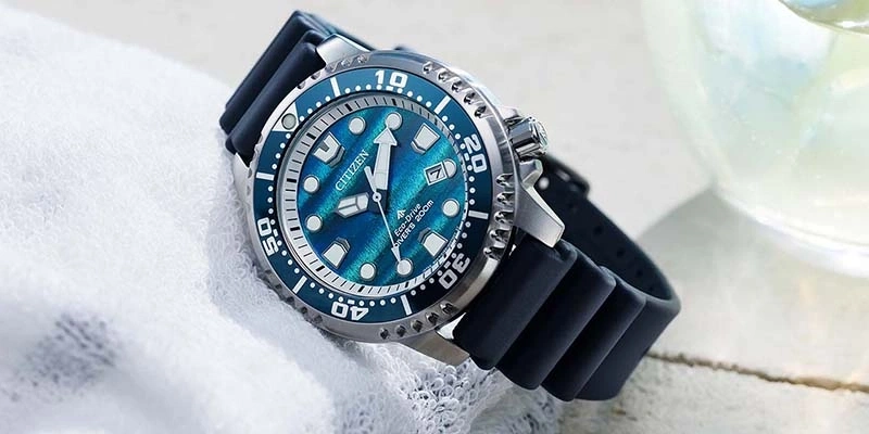 Een blauw Citizen Eco-Drive duikhorloge met rubberen band rust op een witte handdoek.