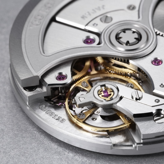 Close-up van een horlogemechanisme met tandwielen en juwelen, ingewikkelde details.