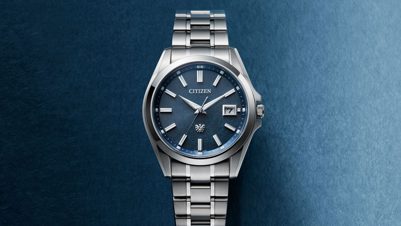 Citizen horloge met blauwe wijzerplaat en zilveren band op blauwe achtergrond