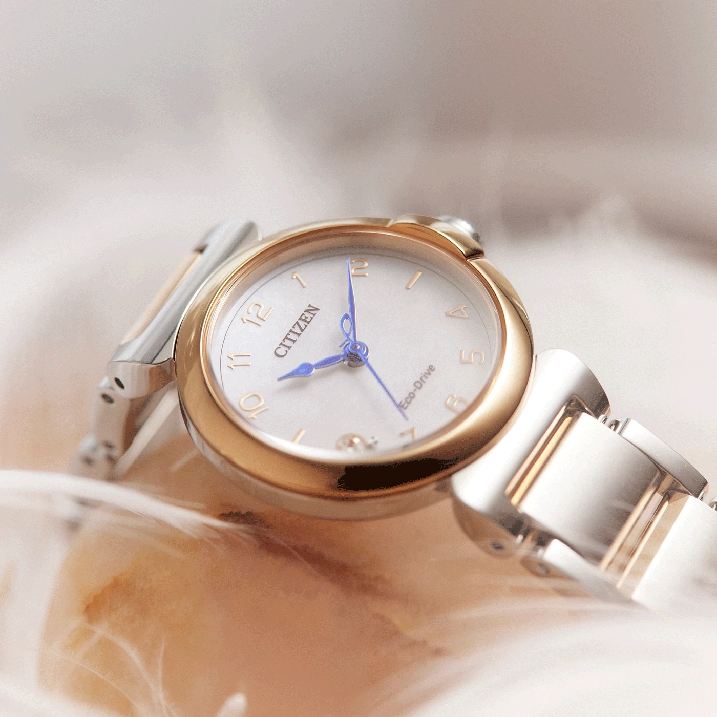 Citizen Eco-Drive horloge met gouden en zilveren accenten op zachte achtergrond