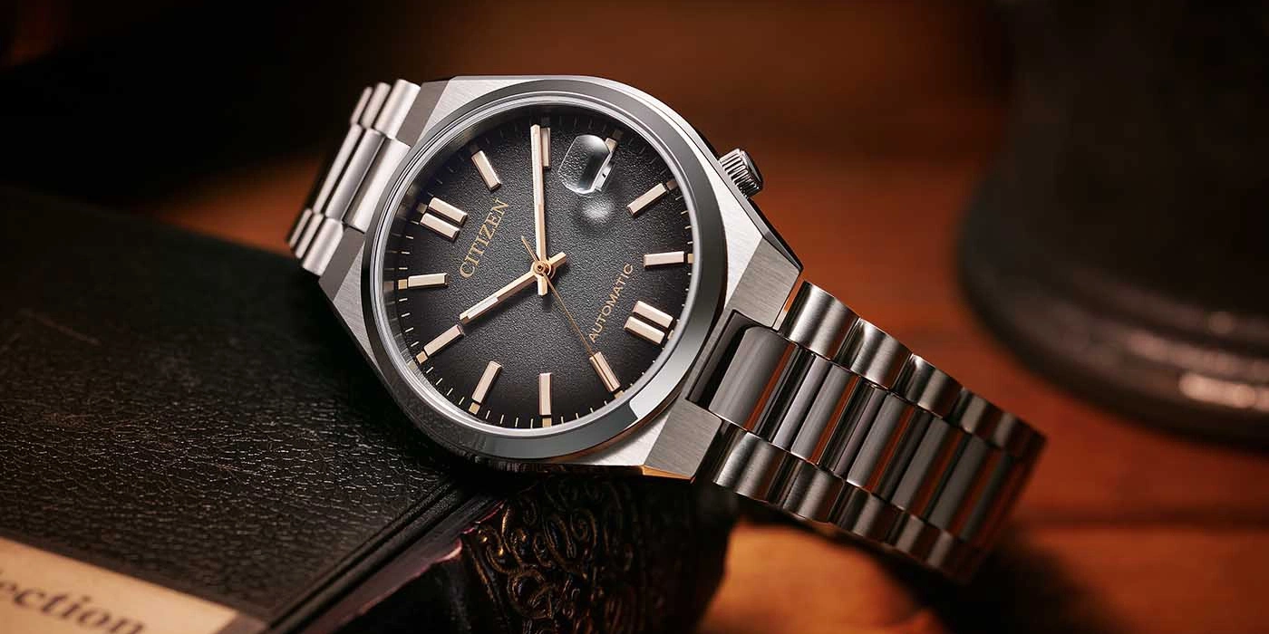 Citizen automatisch horloge met zwarte wijzerplaat en zilveren armband.