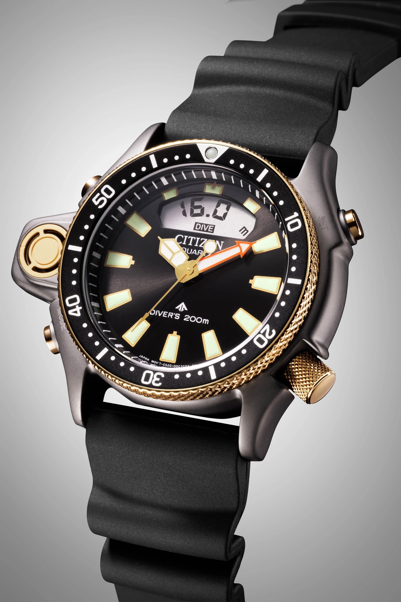 Close-up van een Citizen duikhorloge met zwarte band en gouden accenten.