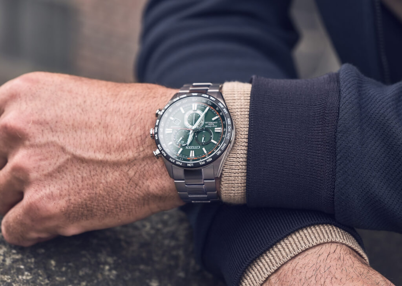 Man met een Citizen horloge met groene wijzerplaat en zilveren band.