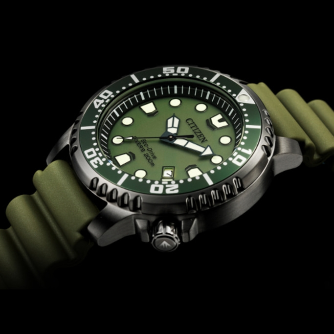 Citizen horloge met groene wijzerplaat en band, zwarte achtergrond, close-up