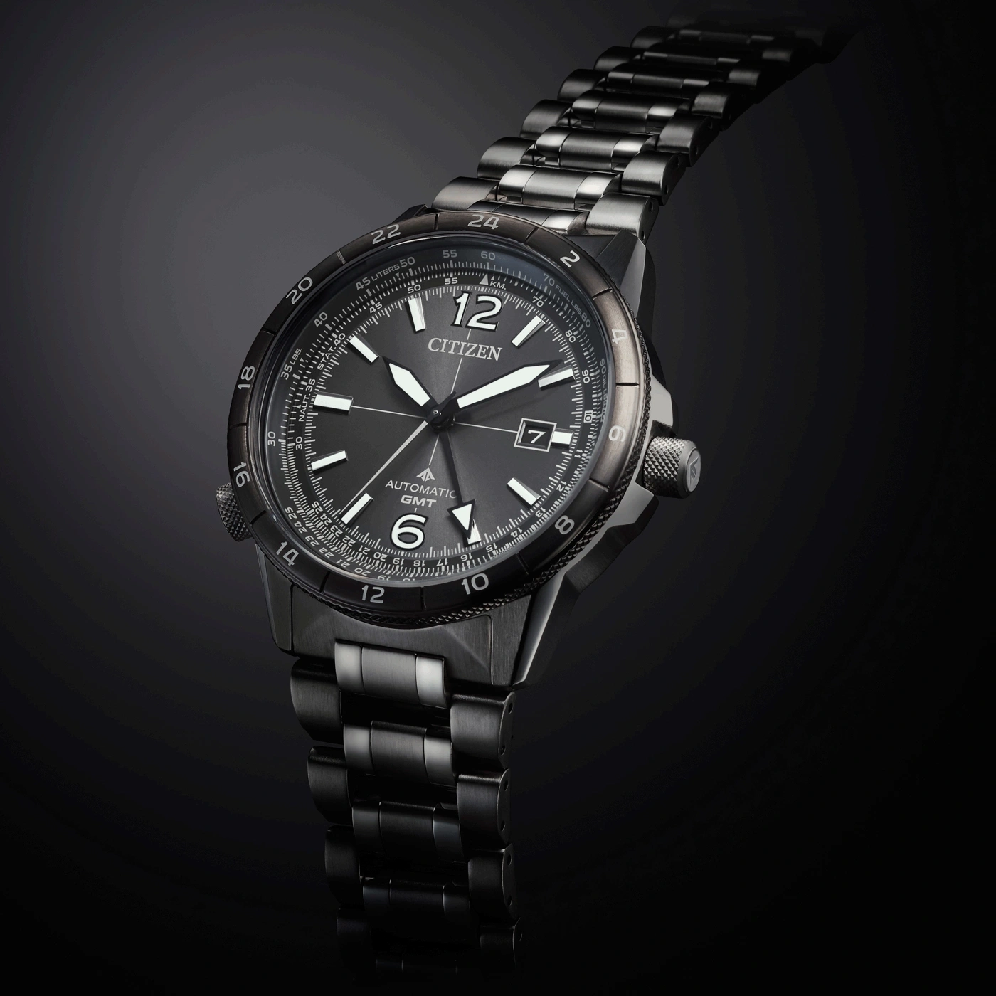 A stylish Citizen automatic GMT watch with a dark metal band, presented against a sleek, dark background.
