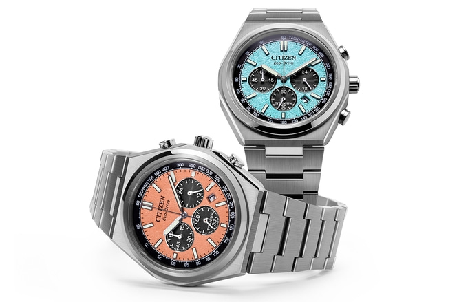 Twee Citizen horloges met blauwe en oranje wijzerplaten, titanium, Eco-Drive en chronograaffuncties.