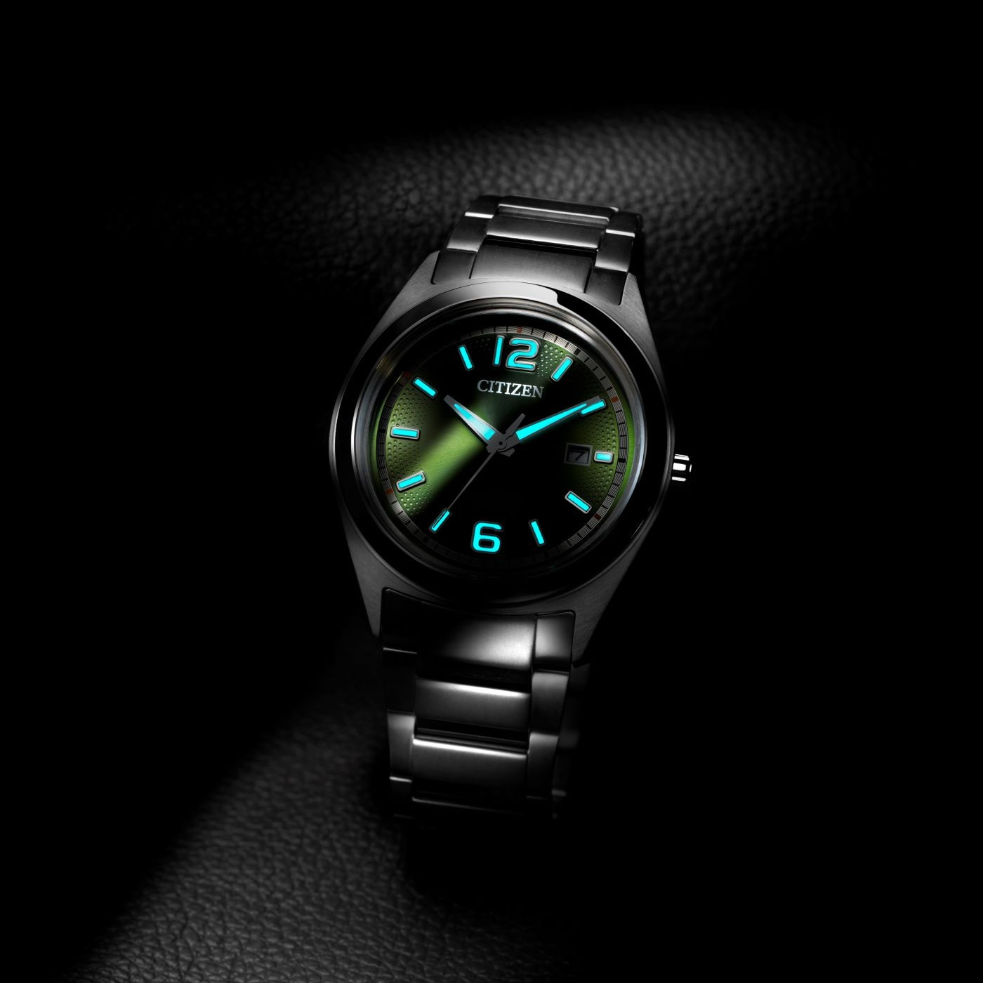 Citizen horloge met oplichtende wijzers en cijfers op donkere achtergrond.