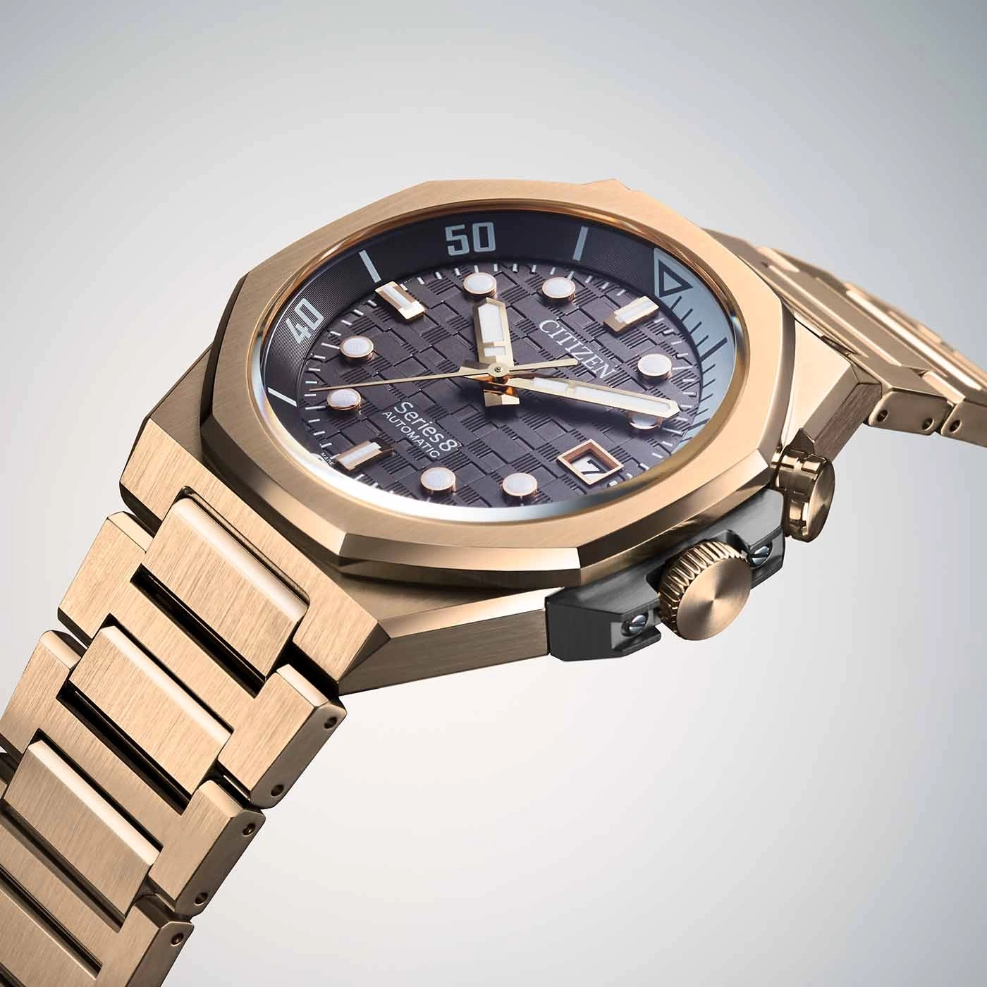 Close-up van een gouden Citizen Series 8 automatisch horloge met een getextureerde wijzerplaat.